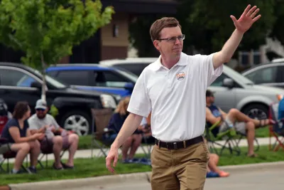 A community leader waves to the crowd during the Fourth of July parade in Brookings, South Dakota.
